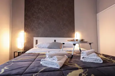 Letto o letti in una camera di A cartulina e Napulè Attico con Vista Porto Ascensore Colazione Inclusa Struttura nel cuore autentico di Napoli a 5 minuti dalla Stazione Centrale e dal Centro Storico AC